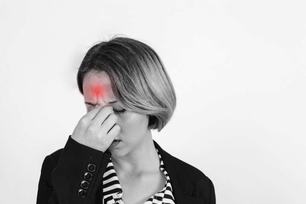 mujer con fuerte dolor de cabeza; sintoma de falta de magnesio